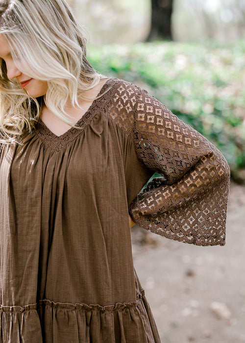 Blonde model wearing mocha colored top with lace sleeves.