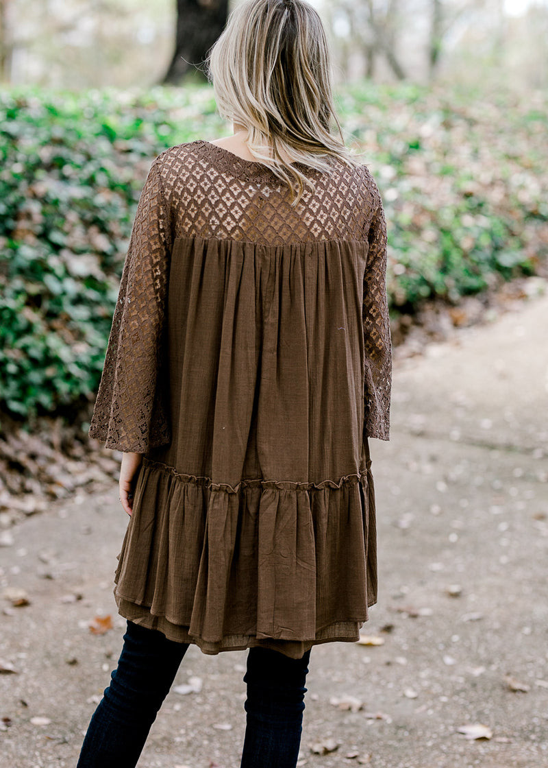 Back view of Blonde model wearing mocha colored top with lace sleeves and back detail.