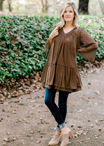 Blonde model wearing mocha colored top with jeans and heeled mules.