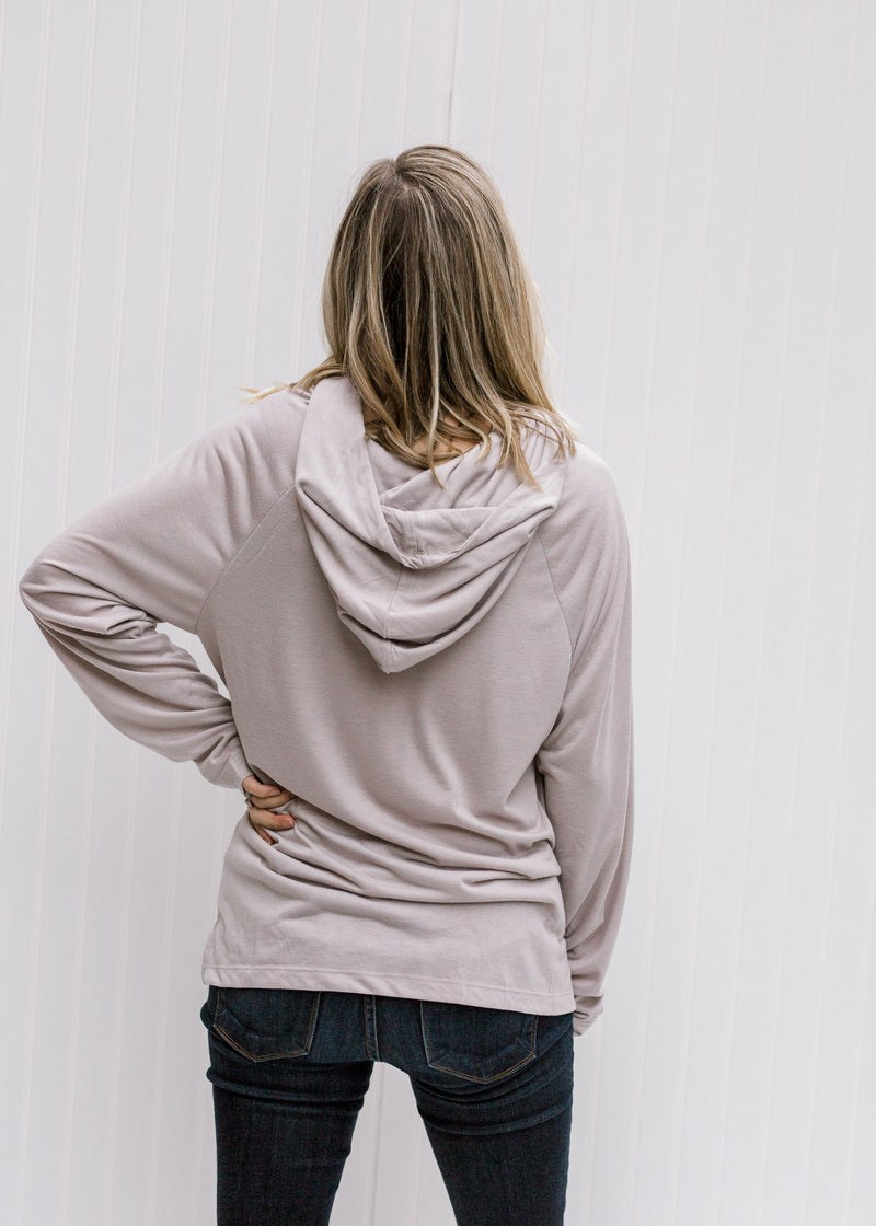 Back view of Blonde model wearing soft silvery taupe hoodie.