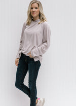 Blonde model wearing soft silvery taupe hoodie with jeans.
