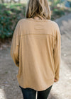 Back view of Blonde model wearing a taupe long sleeve top. 