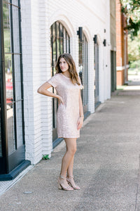 Brunette model wearing short sleeve sequin dress with heels.