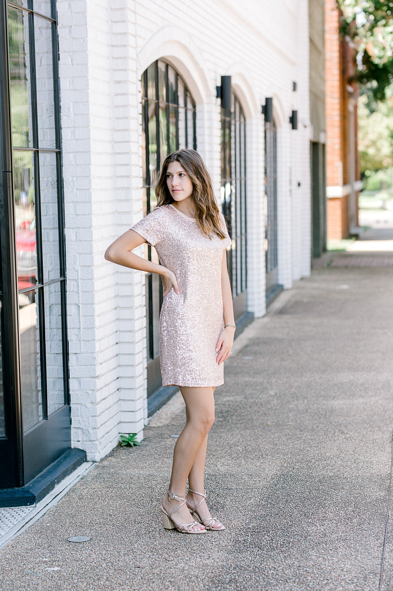 Brunette model wearing short sleeve sequin dress with heels.