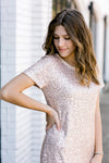 Brunette model with hand on hip, wearing short sleeve sequin dress.