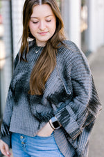 Brunette model wearing mottled charcoal sweater.