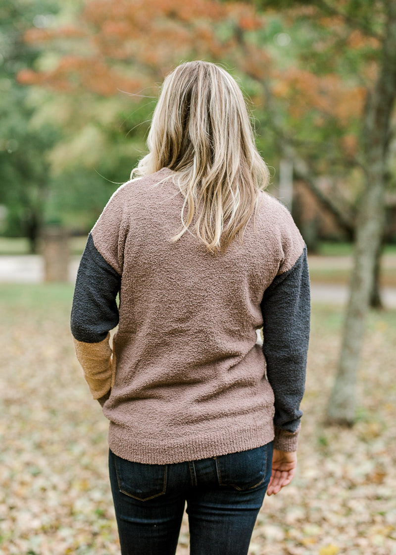 Back view of blonde model wearing color block sweater.