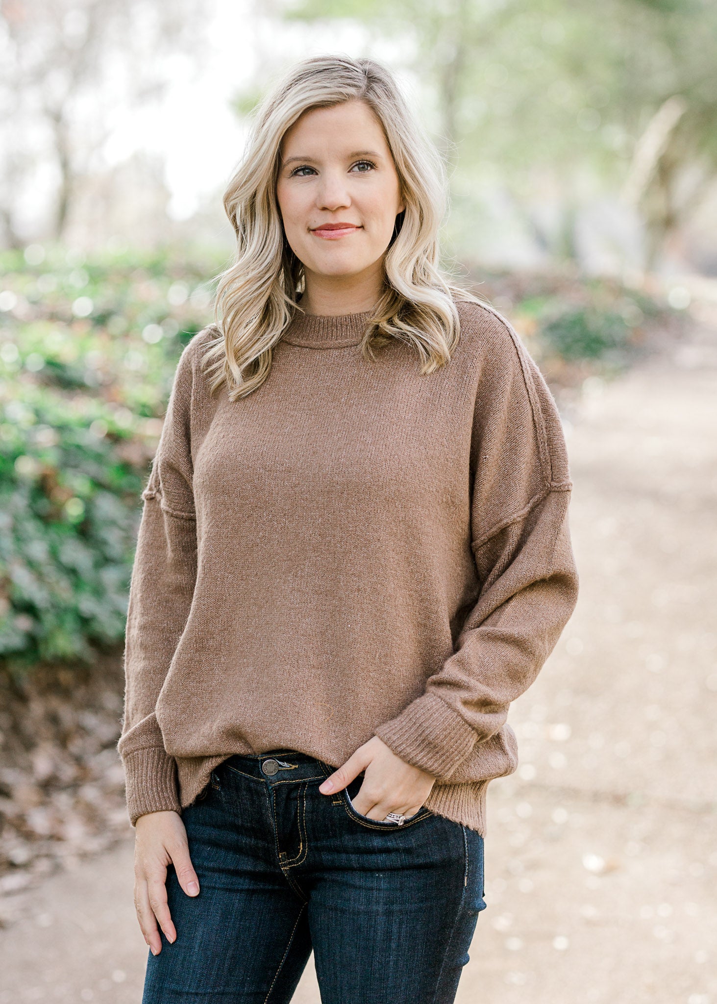 Blonde model wearing light brown sweater. 