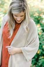 Close up of Blonde model wearing cream duster cardigan with coral top.
