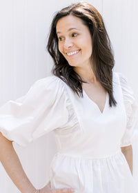 Close up view of bubble short sleeves and v-neck on a white babydoll top. 