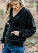 Blonde model wearing black V-neck sweater. 