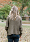 Back view of Blonde model wearing olive cable knit sweater.