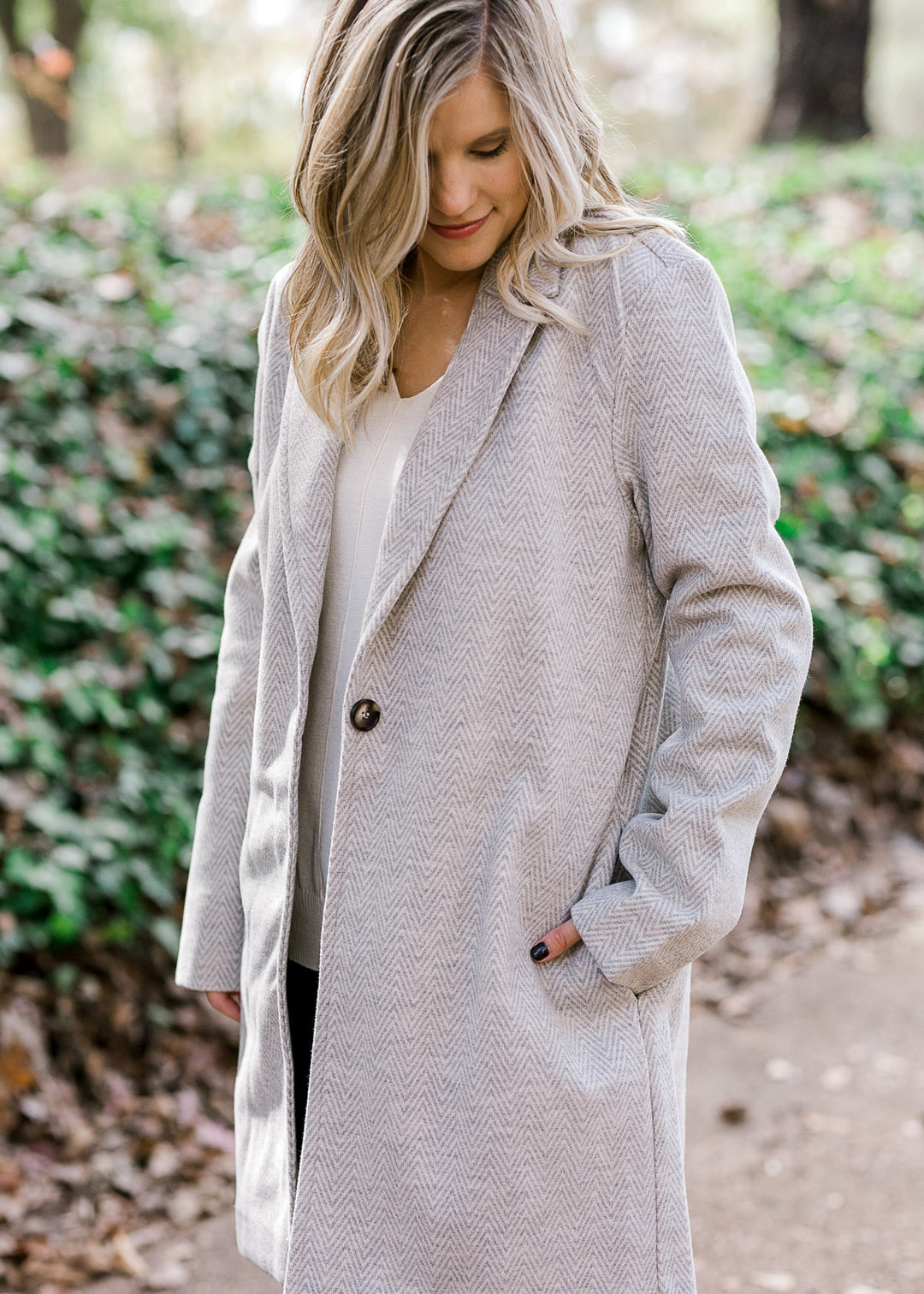 Blonde model wearing herringbone jacket. 