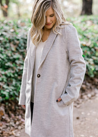Blonde model wearing herringbone jacket. 