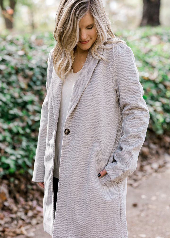 Blonde model wearing herringbone jacket. 
