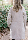 Back view of Blonde model wearing herringbone jacket.
