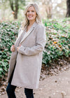 Blonde model wearing herringbone coat with jeans. 