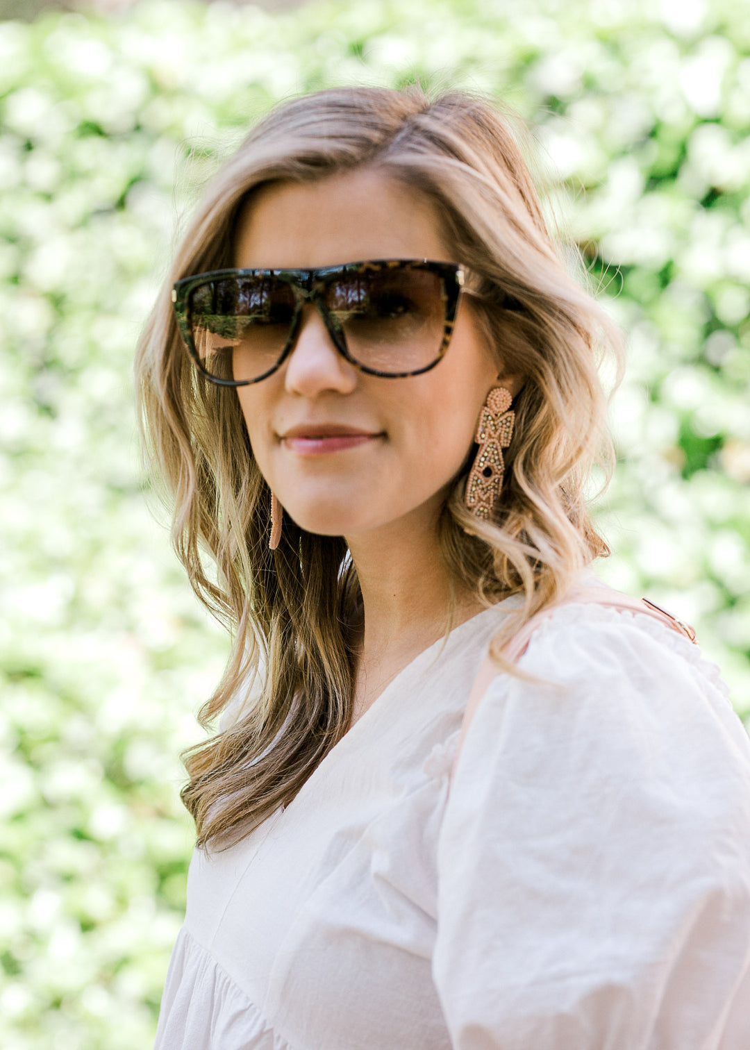 Blonde model wearing brown tortoise glasses with ombré lens. 