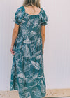 Back view of Model wearing a turquoise midi dress with a cream fern pattern.