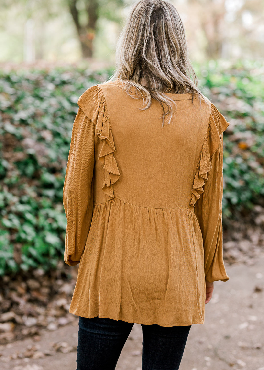 Back view of Blonde model wearing mustard blouse.