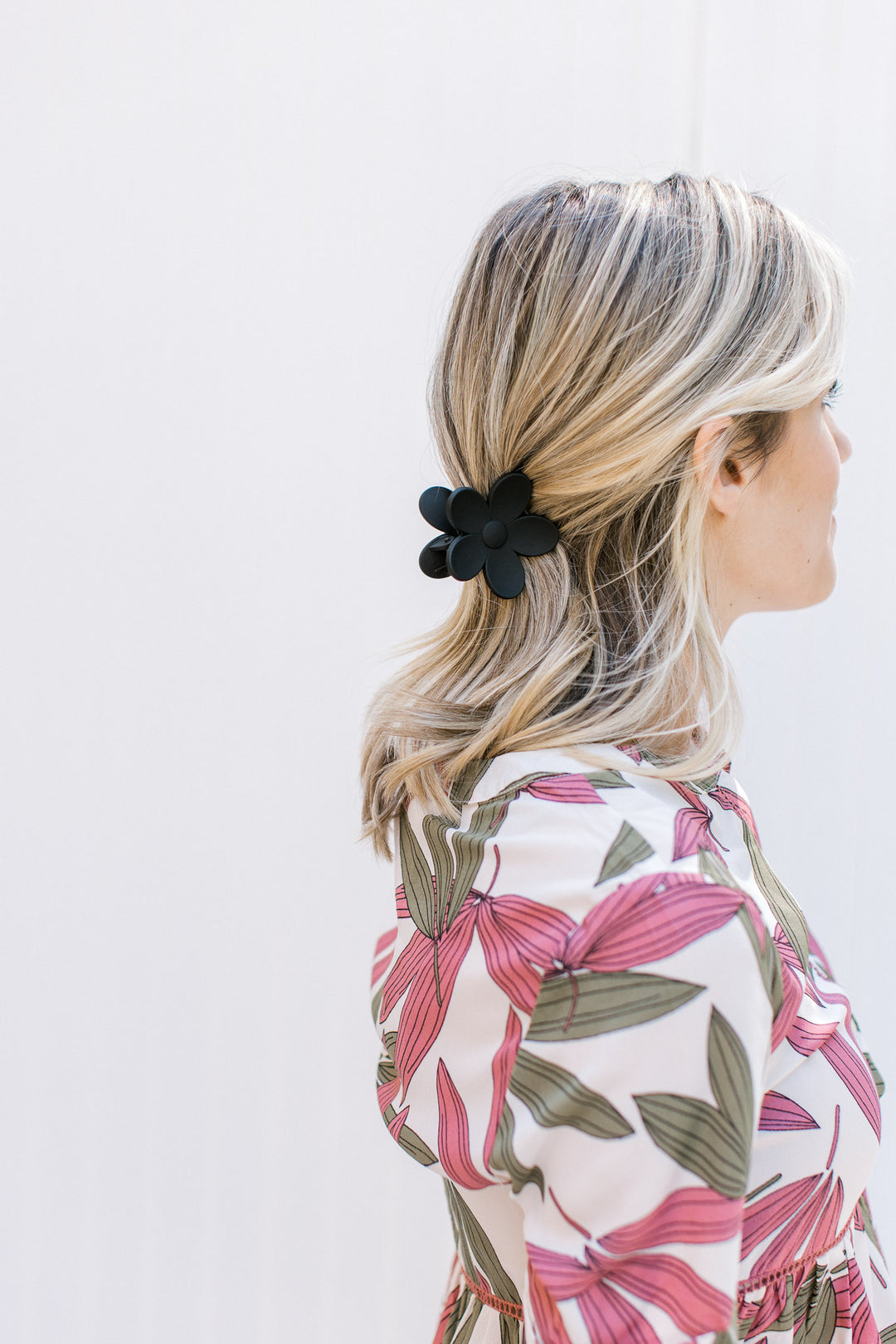 Model wearing a black flower claw hair clip with a matte finish. 