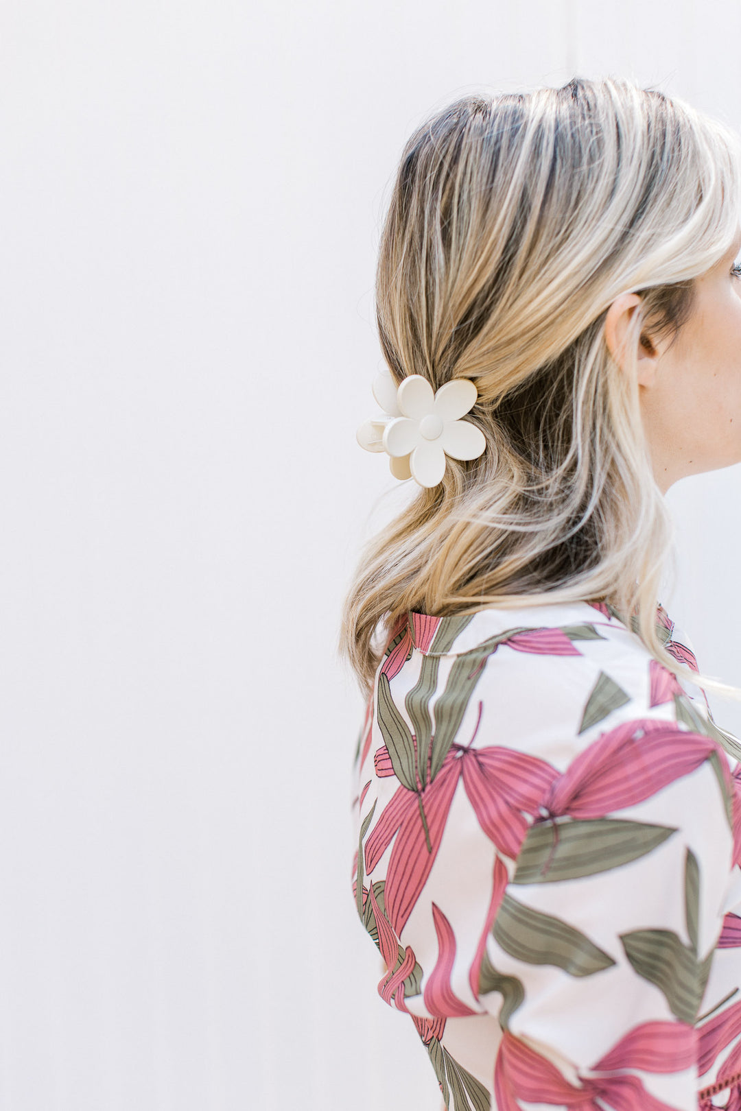 Model wearing a cream flower claw hair clip with a matte finish. 