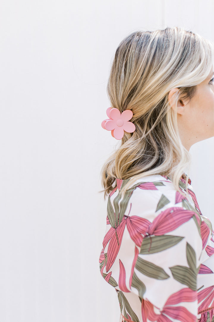 Model wearing a pink flower claw hair clip with a matte finish. 