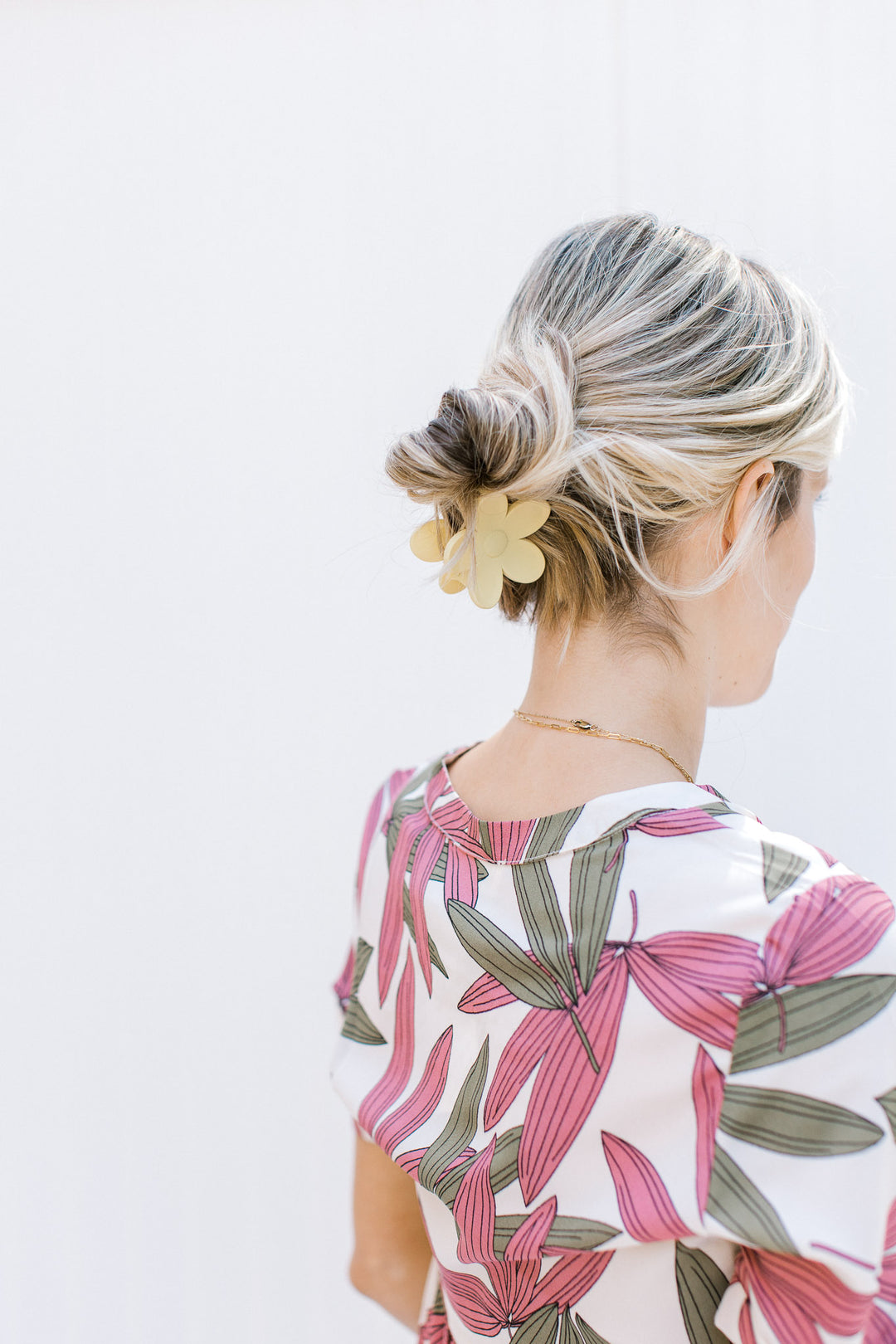 Model wearing a yellow flower claw hair clip with a matte finish. 