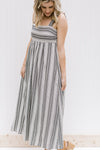 Model wearing black and white striped midi dress with 2 inch straps.