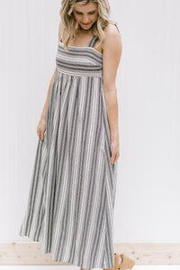 Model wearing black and white striped midi dress with 2 inch straps.