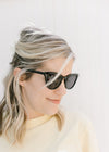 Side view of model wearing all black sunglasses with a black vintage frame. 