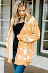 Blonde model wearing a gold cardigan with cream star pattern. 
