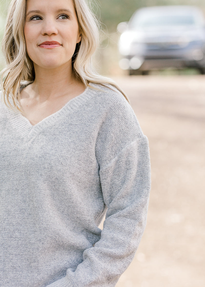 Close up of scalloped v-neck on gray sweater. 
