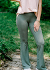 Brunette model wearing sage grey flare legging and jeans.