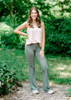 Brunette model wearing sage grey flare legging and tank.