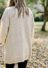 Back view of Blonde model wearing cream cardigan.