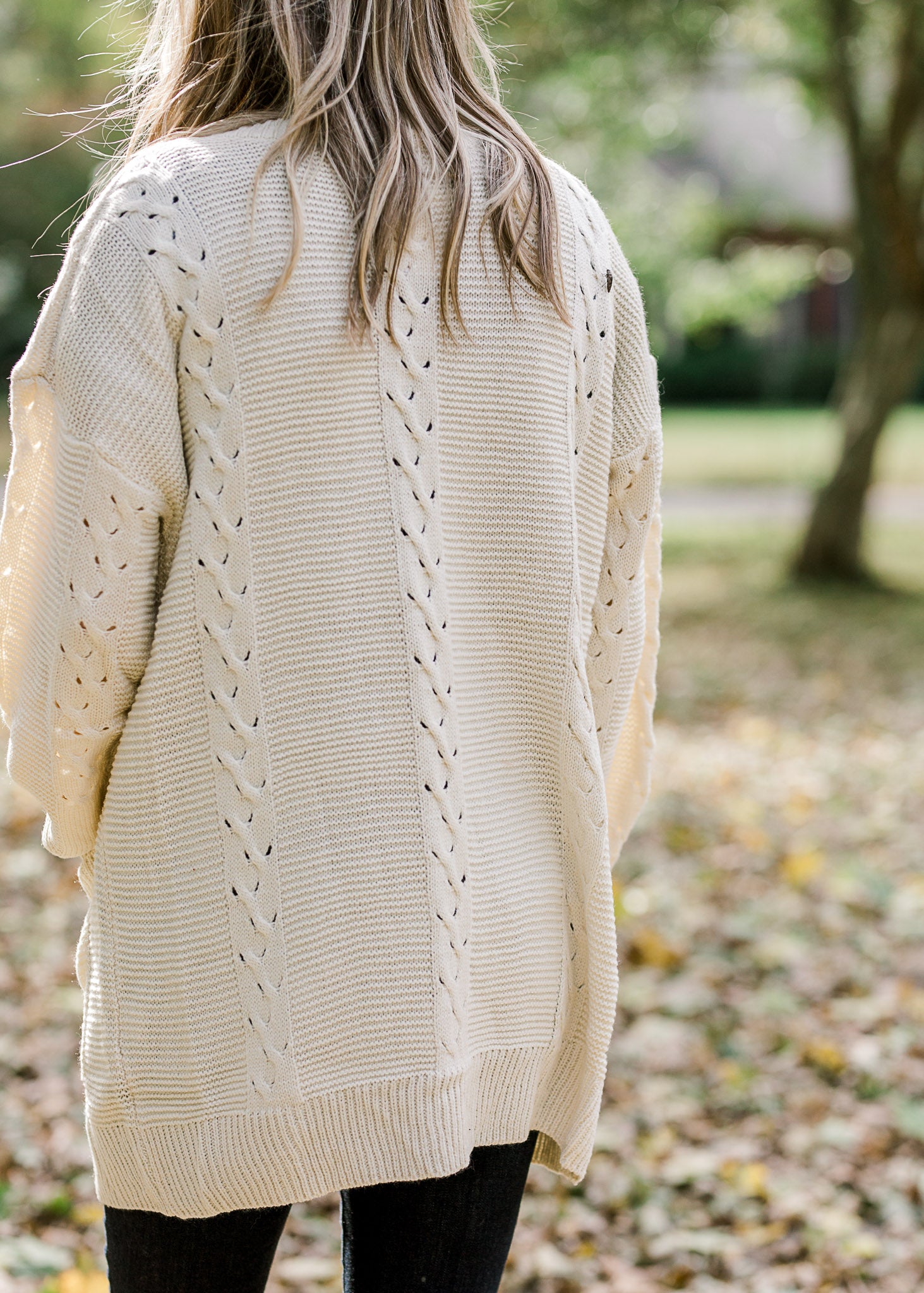 Back view of Blonde model wearing cream cardigan.