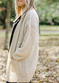 Sleeve view of Blonde model wearing cream cardigan