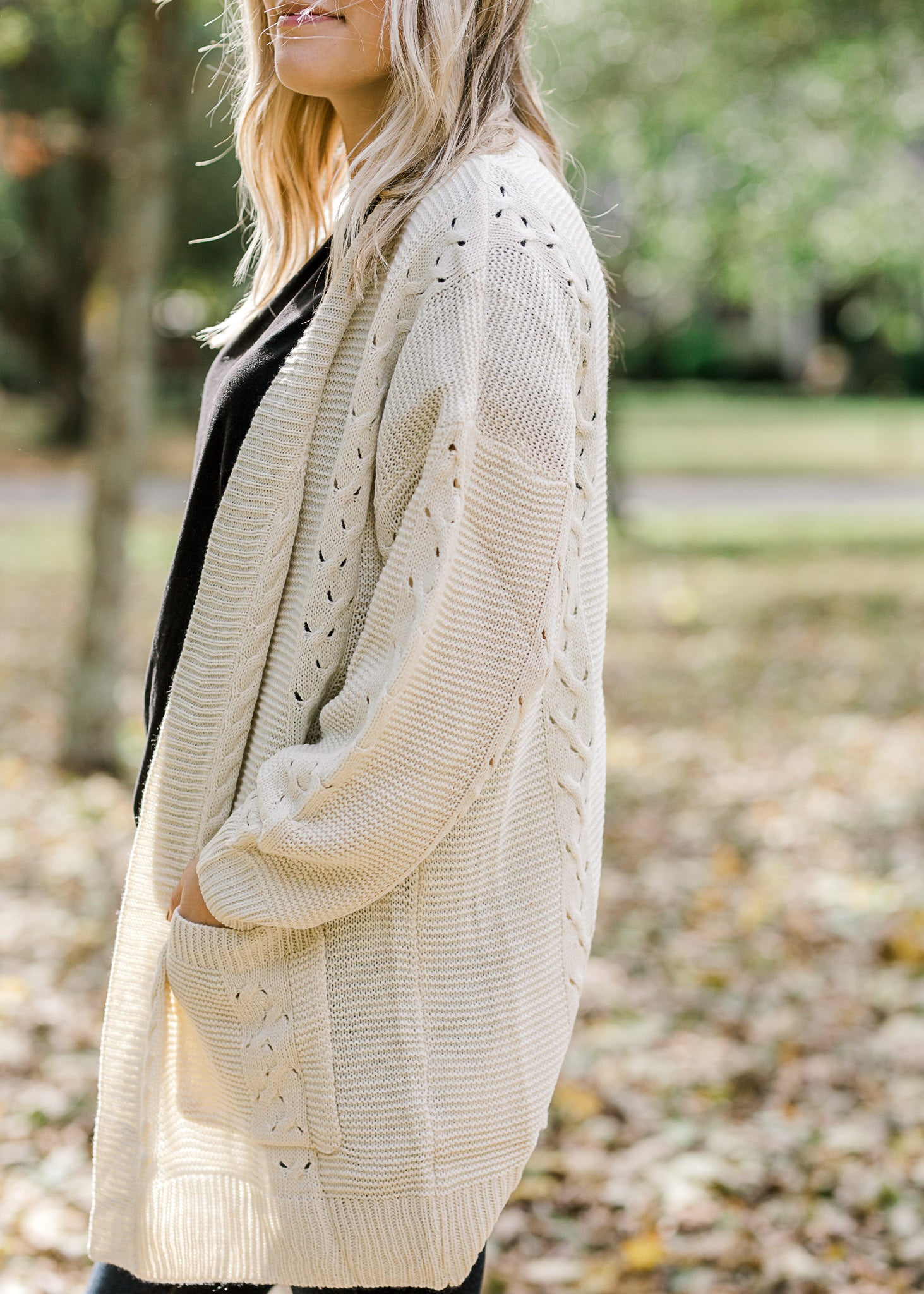 Sleeve view of Blonde model wearing cream cardigan