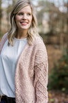 Blonde model wearing cream open weave cardigan with a white top. 