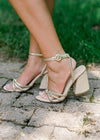 Side view of gold woven strap sandals with  chunky rattan heel.