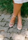 Front view of gold woven strap sandals with chunky heel.