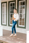 Model wearing double fray hem skinny jeans and slides.