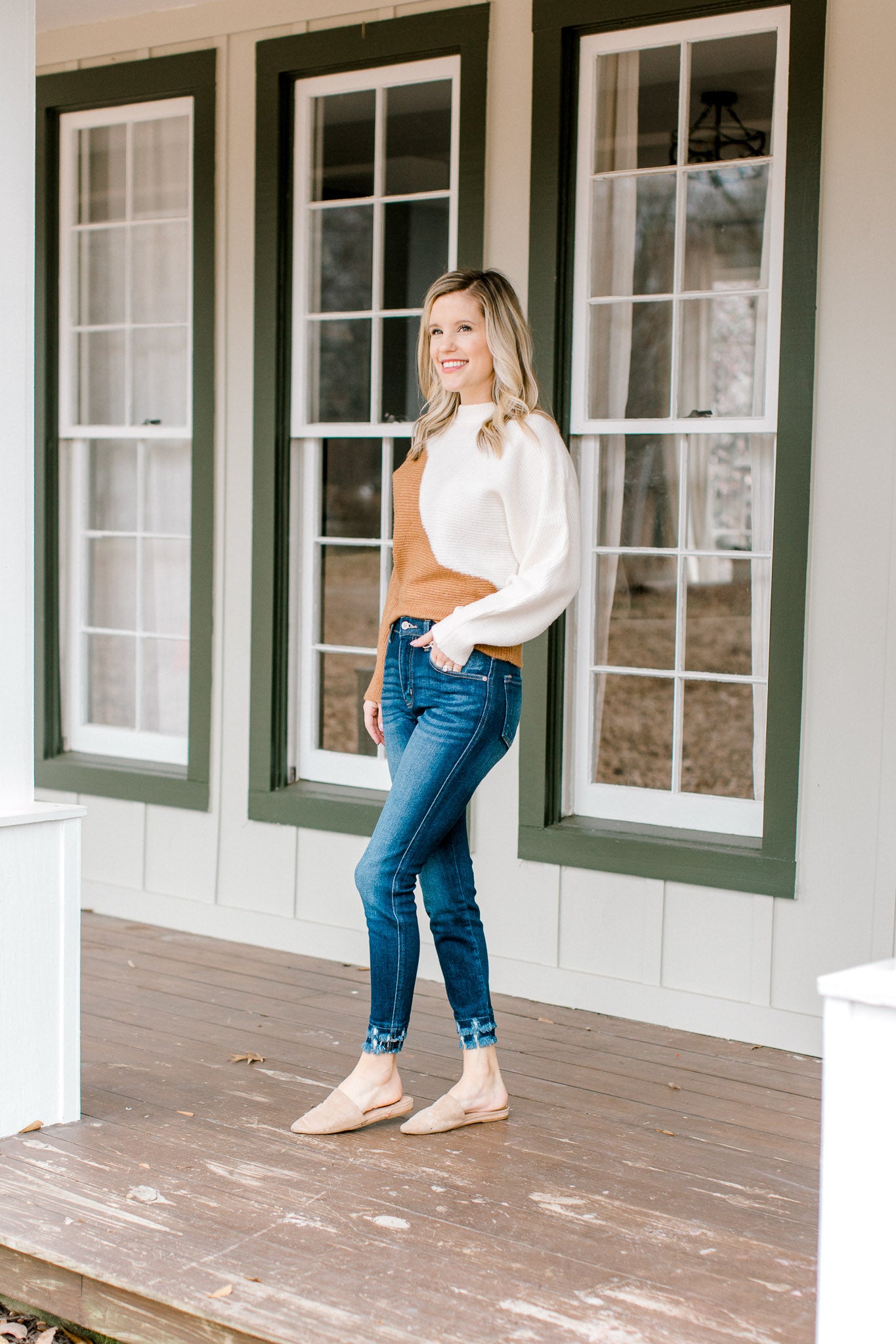 Model wearing double fray hem skinny jeans and slides.
