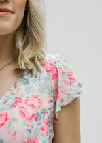 Close up view of Blonde model wearing a pink floral babydoll top.