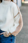 Brunette model wearing sweater with ivory front and Carmel back.
