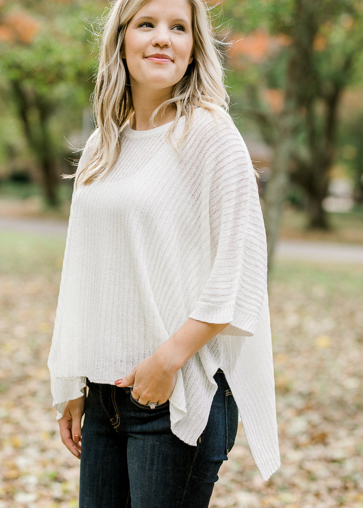 Blonde model wearing ivory cable knit sweater.