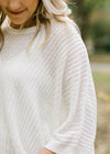 Close up of cable knit on ivory sweater.