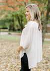 Side view of Blonde model wearing ivory cable knit sweater.
