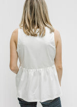 Back view of  Blonde model wearing a white tank with Aztec embroidery